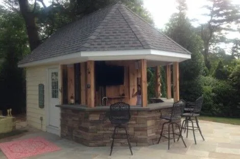 Beautiful outdoor cabana with bar and seating area, perfect for outdoor gatherings in Long Island. Outdoor cabana with bar and seating area in Long Island setting.