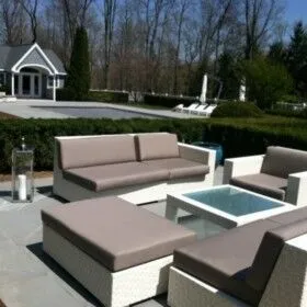 Modern outdoor furniture with a fire pit in a landscaped backyard.