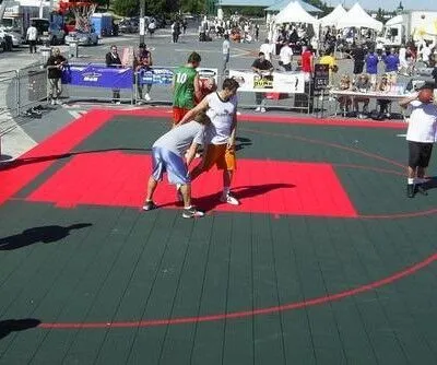 Participants playing basketball on an outdoor court during a community festival in Long Island. People playing basketball on outdoor court at festival in Long Island.