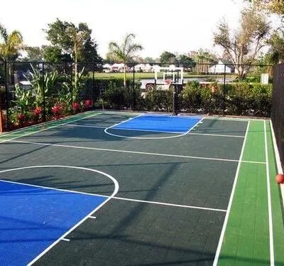 Beautiful outdoor basketball court with vibrant colors and surrounding greenery in a Long Island backyard. Basketball court with outdoor furnishings in Long Island residential backyard.