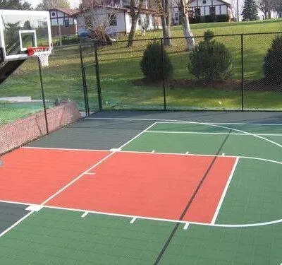 A well-maintained outdoor basketball court with fencing, perfect for residential recreation and sports activities. Outdoor basketball court with fencing and surrounding greenery in a residential area.