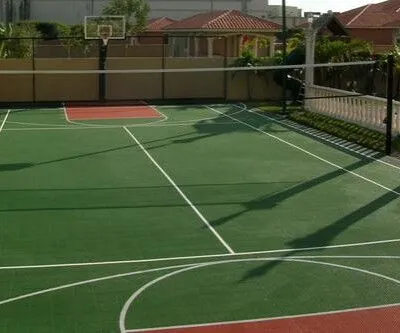 A well-maintained residential outdoor basketball court with hoop, perfect for family and friends recreation. Residential outdoor basketball court with hoop and court markings.