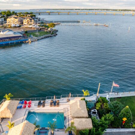 Aerial view of a Long Island waterfront pool with outdoor furnishings and scenic water views.