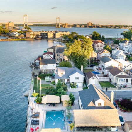 Aerial view of a Long Island waterfront home with pool and outdoor furniture.