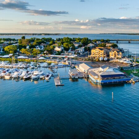 Aerial view of Long Island marina with boats and waterfront homes.
