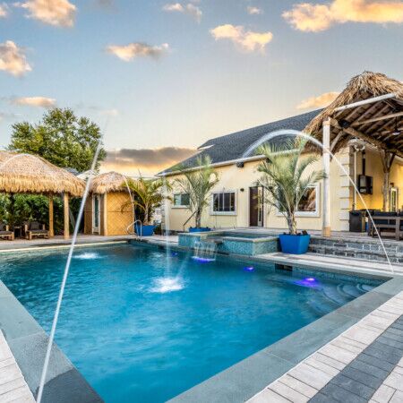 Luxury inground pool with water features and outdoor furnishings in Long Island.