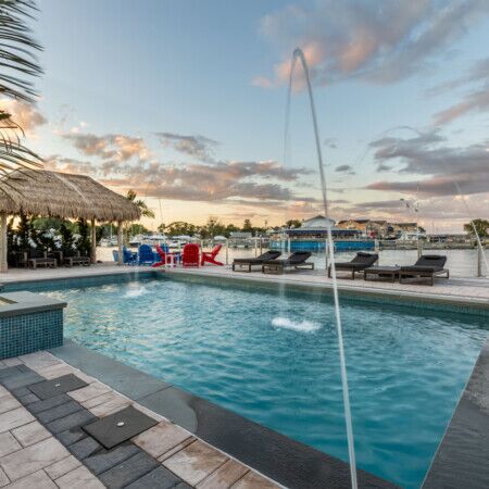 Luxury inground pool with outdoor furniture and waterfront view in Long Island.