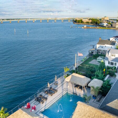 Beautiful waterfront pool with outdoor furnishings and scenic Long Island views.