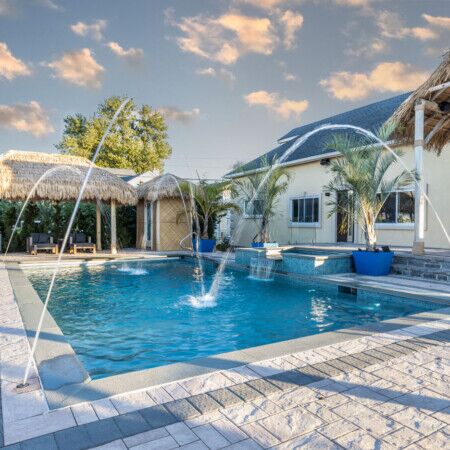 Beautiful inground pool with fountains and outdoor seating on Long Island.