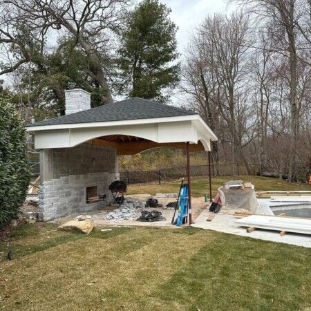 Backyard with in-ground pool, covered patio, and outdoor furnishings in Long Island, perfect for outdoor living. Beautiful backyard with pool, outdoor furniture, and covered patio in Long Island.