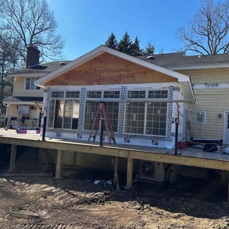Ongoing construction of a backyard inground pool with large windows and outdoor living space in Oyster Bay. Construction of an inground pool with large windows and outdoor deck in progress.