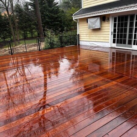 Beautifully finished wooden pool deck with rain reflections, perfect for outdoor entertaining in Oyster Bay. Refined wooden pool deck with rain reflections in Oyster Bay.