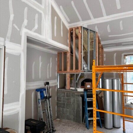 Construction site showing drywall framing and scaffolding inside a building under construction. Interior wall framing and drywall installation underway in a new building.