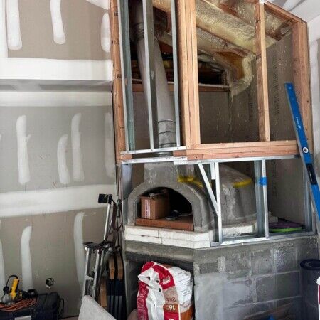 Ongoing inground pool installation with framing and plumbing in progress at a backyard. Construction of an inground pool with wooden framing and plumbing setup.