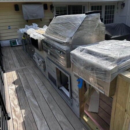 Recently installed outdoor kitchen with grill and countertops on a backyard deck. New outdoor kitchen with grill and countertop on deck.