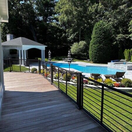 Elegant backyard featuring a custom inground pool, outdoor seating, and landscaped greenery in Oyster Bay. Beautiful backyard with inground pool, outdoor furniture, and lush landscaping in Oyster Bay.