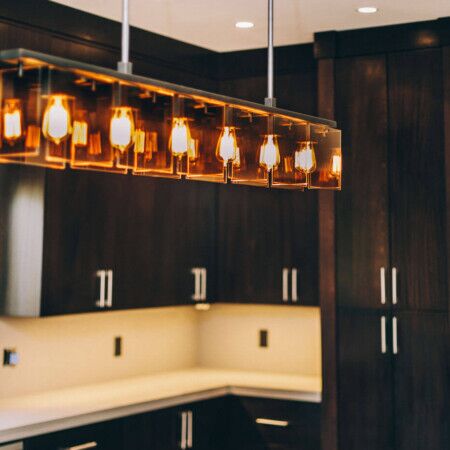 Contemporary kitchen with dark wood cabinets and stylish pendant lights.