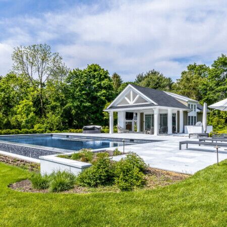 Elegant backyard with inground pool, outdoor furnishings, and a cabana for outdoor relaxation. Luxury inground pool with outdoor furnishings and cabana in a lush backyard.