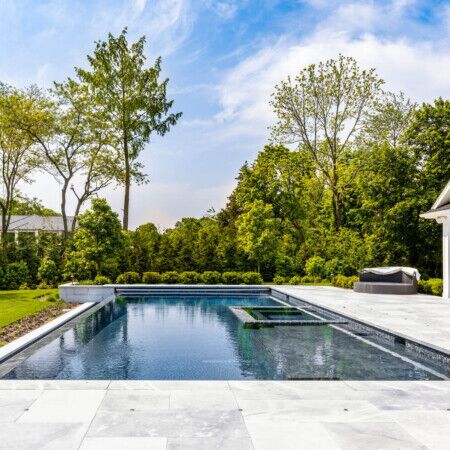Elegant inground pool with surrounding outdoor living space in Long Island, perfect for outdoor relaxation and entertainment. Luxury inground pool with modern design and outdoor furnishings in Long Island.