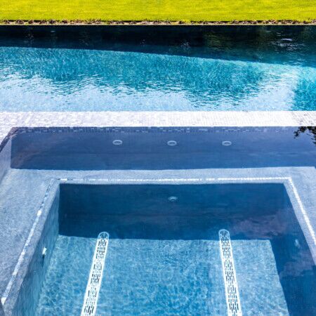 Elegant inground pool with hot tub and outdoor furnishings in Syosset, Long Island. Luxury inground pool with built-in hot tub and modern design.