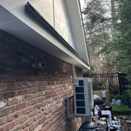Exterior view of cabana construction with HVAC system on brick wall.