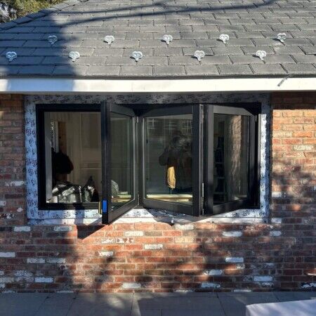 New black-framed window installation on brick wall in Manhasset.