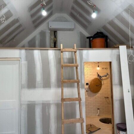 Interior view of a partially built cabana with ladder and construction materials.