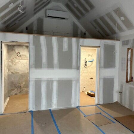 Interior of a house under construction with drywall and ceiling installation.