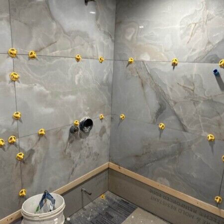Interior wall tiling in progress for Manhasset cabana with wall anchors installed.