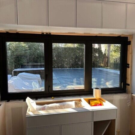 Construction site of a cabana with large window and outdoor view.