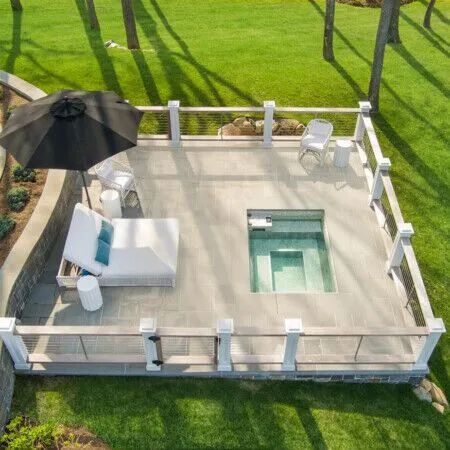Beautiful outdoor deck with pool, umbrella, and seating in Long Island.