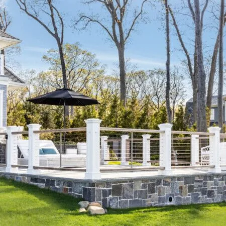 Beautiful outdoor pool deck with seating and umbrella in Long Island.