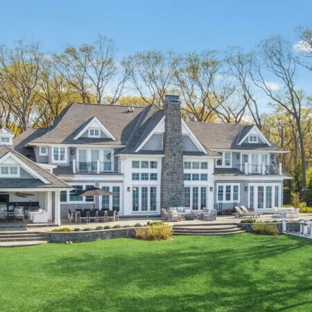 Elegant Long Island home with outdoor pool and lush lawn.