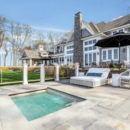 Luxury pool area with outdoor furniture and view of Lloyd Harbor.