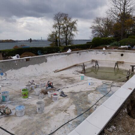 Ongoing inground pool installation at a Long Island property with scenic water views in the background. Inground pool construction site with tools and materials on Long Island.