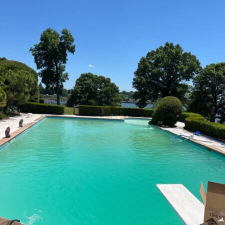Luxury inground pool installed by All Island Group in Long Island with outdoor furnishings and lush greenery. Beautiful inground pool with scenic outdoor setting in Long Island.