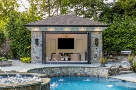 Elegant inground pool with outdoor furnishings and lush landscaping in Long Island, perfect for outdoor living. Luxury inground pool with outdoor entertainment area in Long Island.