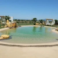 Beautiful inground pool with natural rock accents and outdoor lounging areas in Long Island, NY. Inground pool with natural rock features and outdoor furnishings in Long Island.