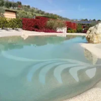 Luxury inground pool with water features and outdoor seating in Long Island, perfect for outdoor living. Beautiful inground pool with water features and outdoor furnishings in Long Island.