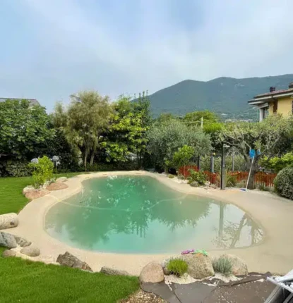 Beautiful backyard with in-ground pool, outdoor furnishings, and lush landscaping.