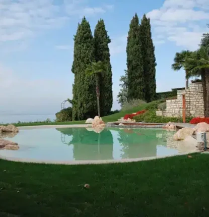 Luxury inground pool with natural rocks and lush landscaping in Long Island.