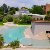 Elegant inground pool with lush landscaping and outdoor seating in Long Island. Beautiful inground pool with surrounding greenery and outdoor furnishings.