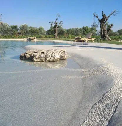 Beautiful inground pool with natural stone accents and outdoor seating.