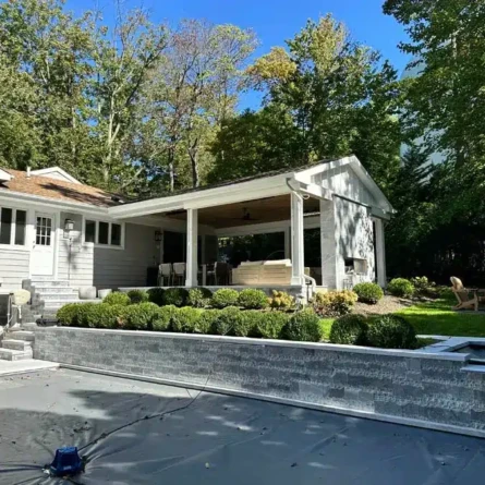 Elegant outdoor pool area with seating and landscaping, perfect for outdoor entertaining in Long Island. Beautiful backyard with inground pool, outdoor furnishings, and lush landscaping in Long Island.