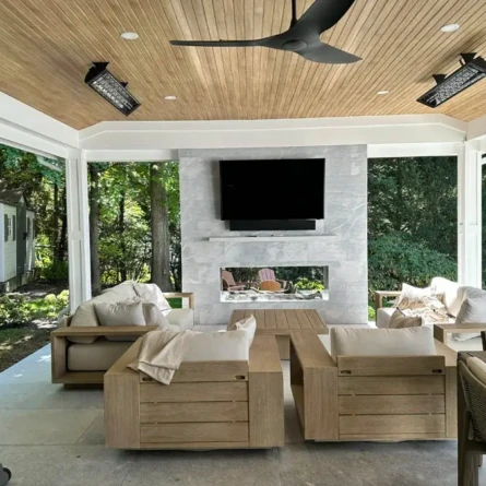 Elegant outdoor living space with cozy seating, a TV, and scenic views of greenery. Modern outdoor living area with comfortable seating and a TV.