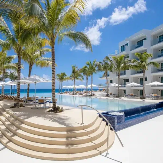Elegant pool area with palm trees, outdoor furnishings, and ocean view in Long Island. Luxury pool area with palm trees and ocean view in Long Island.