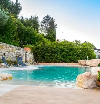 Beautiful inground pool with outdoor furnishings in Long Island setting.