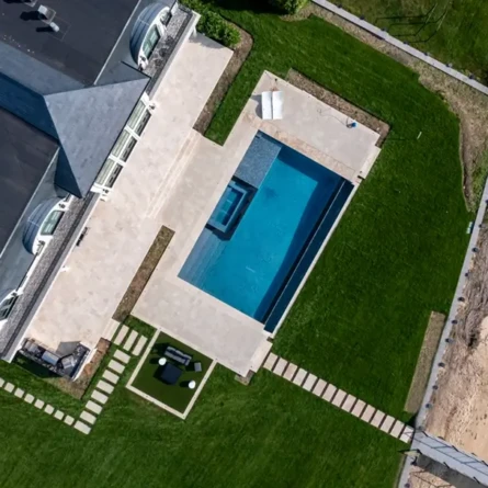 Aerial view of a Long Island backyard with a new inground pool and outdoor furnishings.