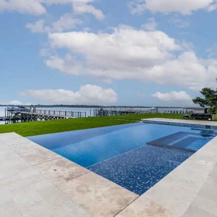 Beautiful inground pool with scenic waterfront view and outdoor seating on Long Island.