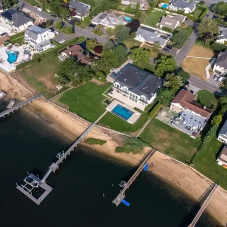 Aerial view of Long Island waterfront home with pool and dock.